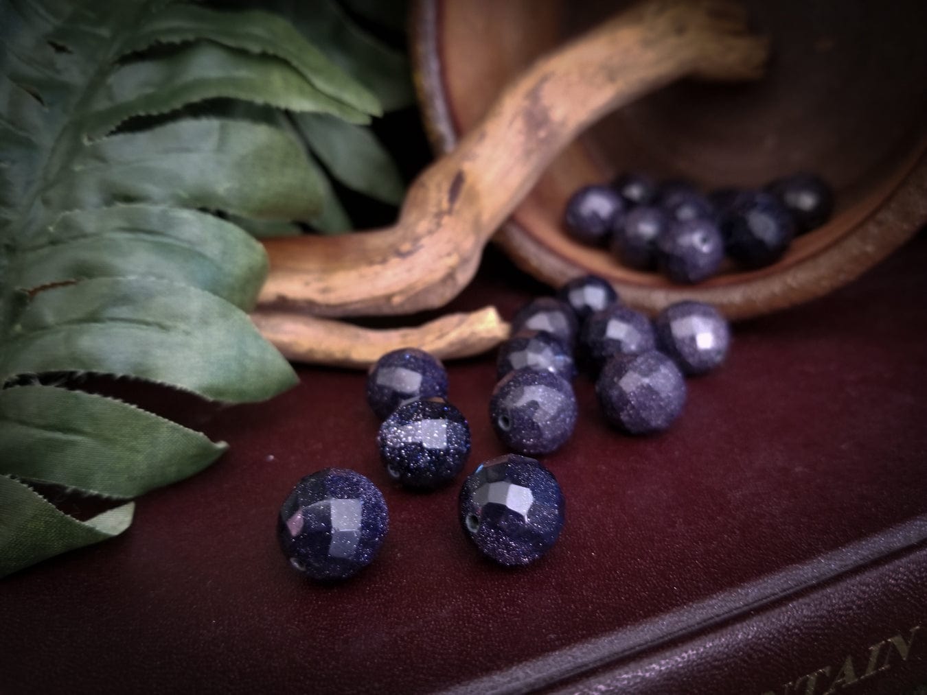 Faceted goldstone beads with deep blue sparkles.