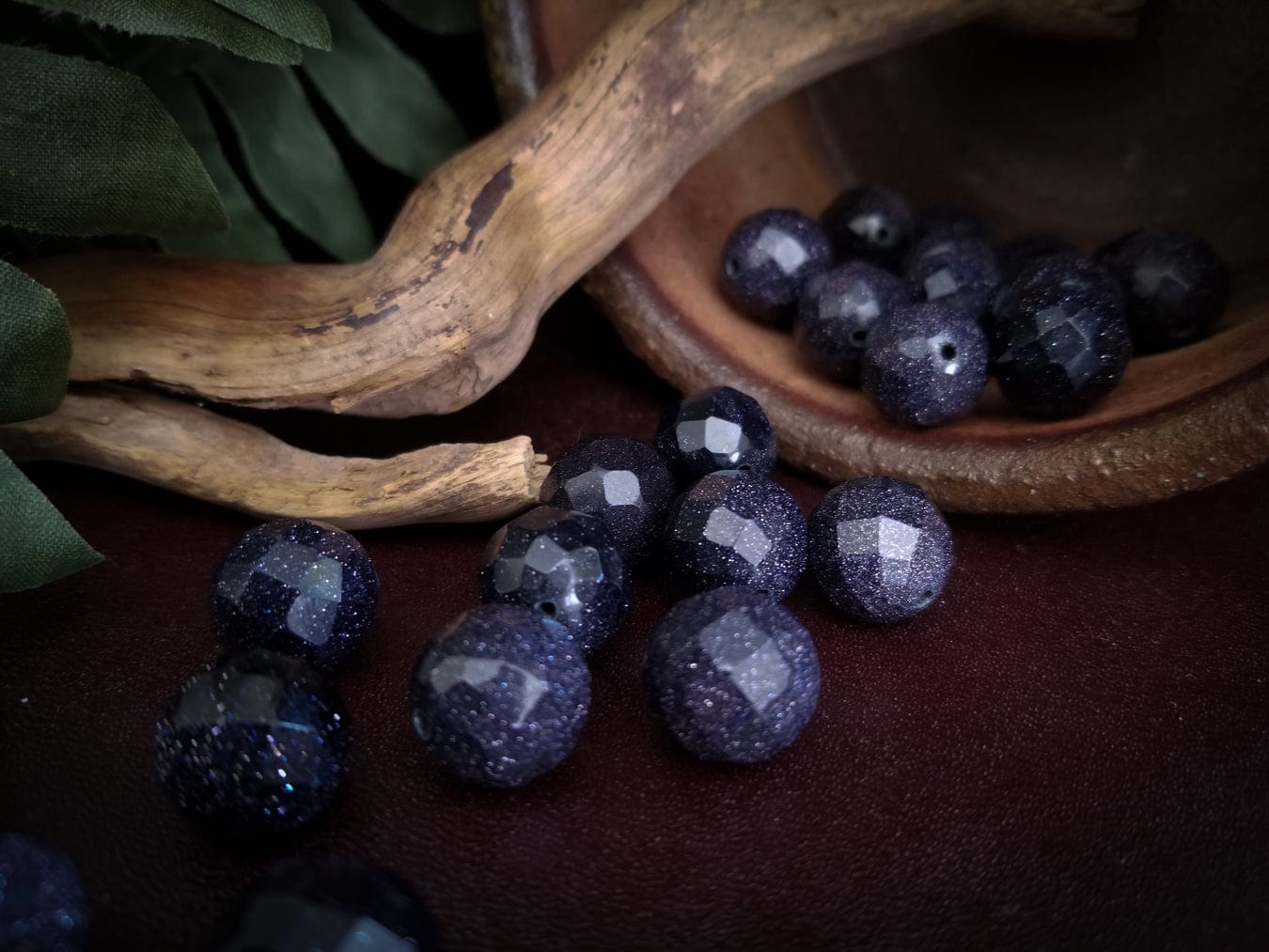 Faceted goldstone beads with deep blue sparkles.