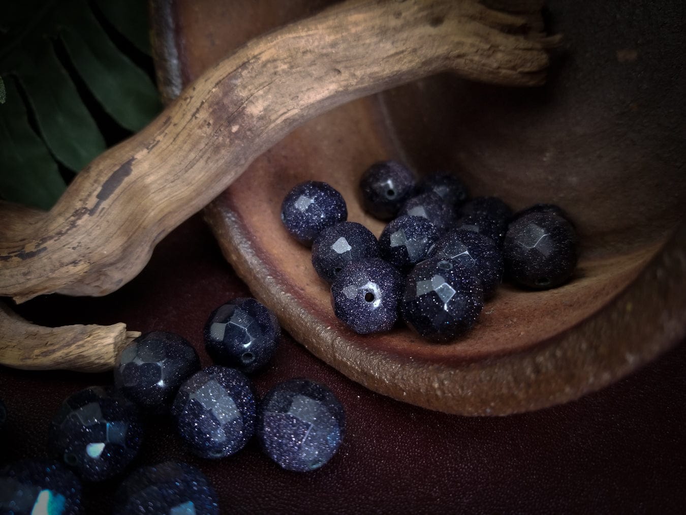 Faceted goldstone beads with deep blue sparkles.