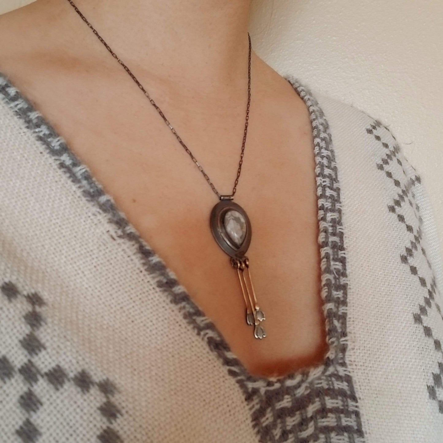 Model wearing the Snowdrop Necklace No. 2 - Tear drop Mexican Agate (white and grey colors) set in sterling silver and brass with 3 individual hand engraved snowdrop flowers hanging from brass fringe. All hanging from a sterling silver box chain.