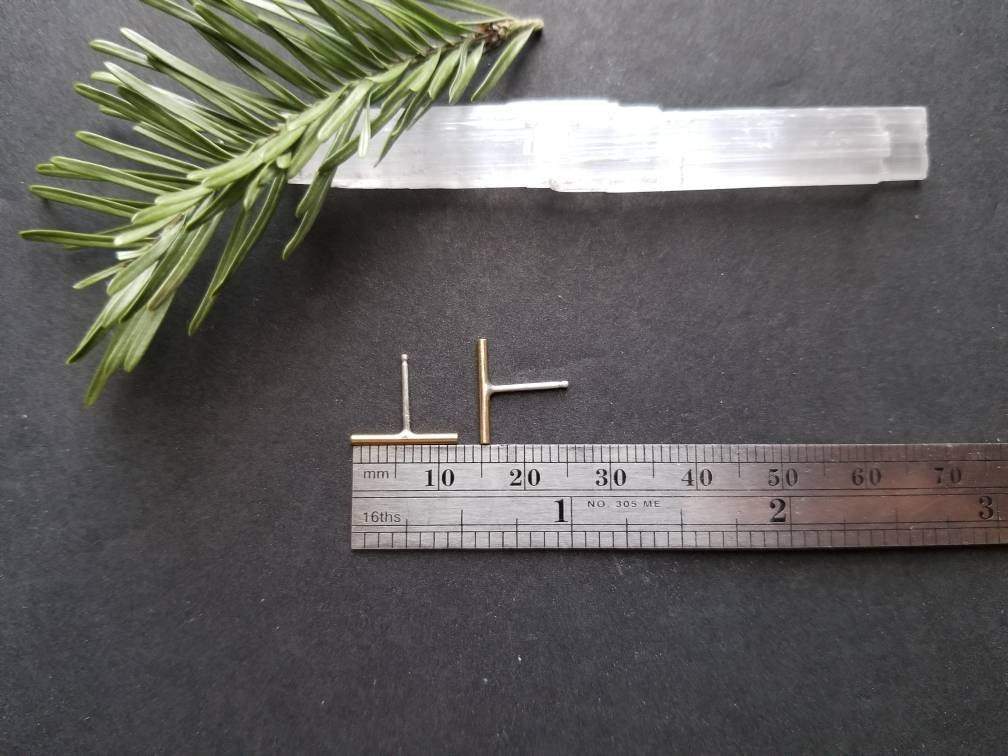 Showing measurements of the handmade brass bar studs with sterling silver posts. Brass bars measure ¼ inches in length.