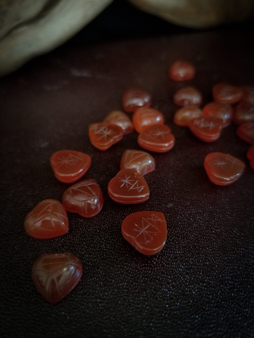 Red carnelian heart cabochons with carved scarab beetle designs.