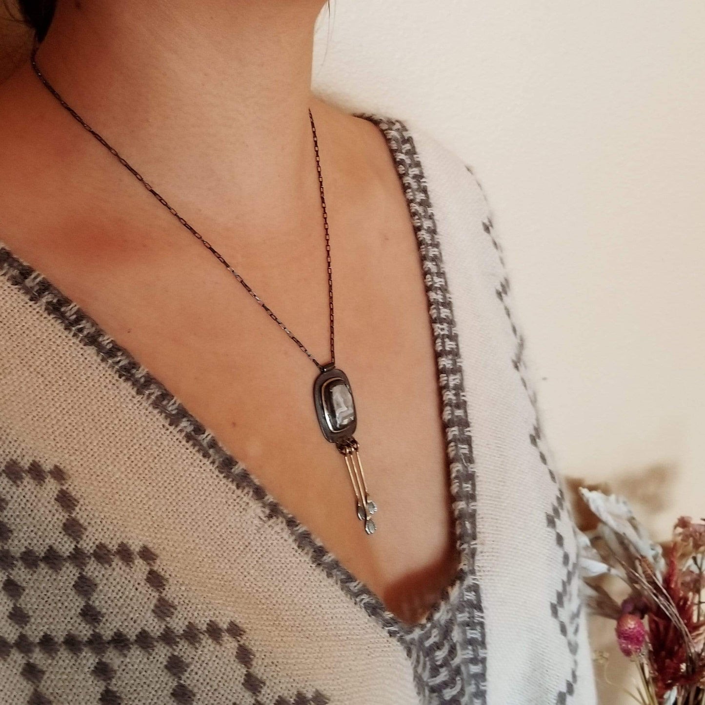 Side angle of model wearing  Snowdrop Necklace No. 1 - Cushion cut (rounded rectangle) Mexican Agate set in sterling silver and brass with 3 individual hand engraved snowdrop flowers hanging from brass fringe. All hanging from a sterling silver box chain. 