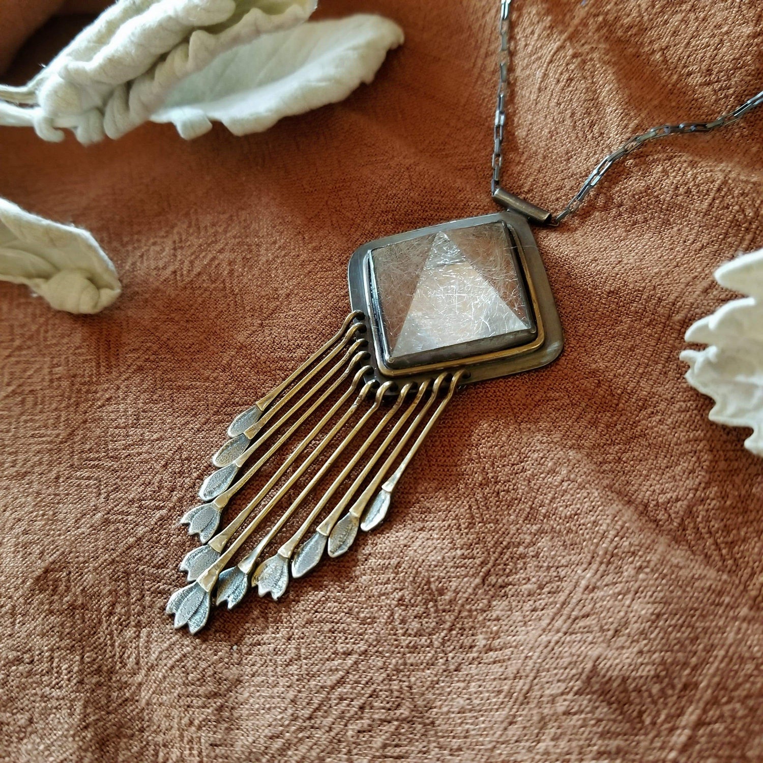 Handmade one of a kind necklace with rutilated quartz set in sterling silver and brass with eleven hand engraved snowdrop flower fringe dangles. All hanging on a sterling silver chain. 
