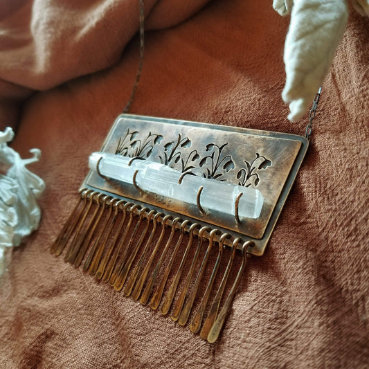 Handmade one of a kind necklace made with brass, sterling silver, and selenite. Brass is hand pierced with a meadow of snowdrop flowers sitting on top of a pronged set selenite wand. Hammered brass paddle fringe hang below. All hanging on a sterling silver chain.